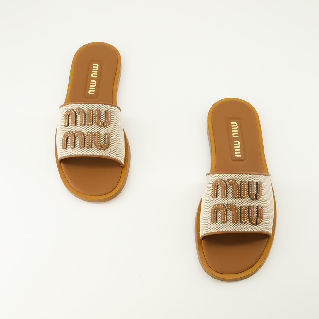 Imagen de las Mules de lona y cuero marrón de la marca Miu Miu para mujer - Temporada Primavera-Verano 2026 - Vista de cima do par de sapatos