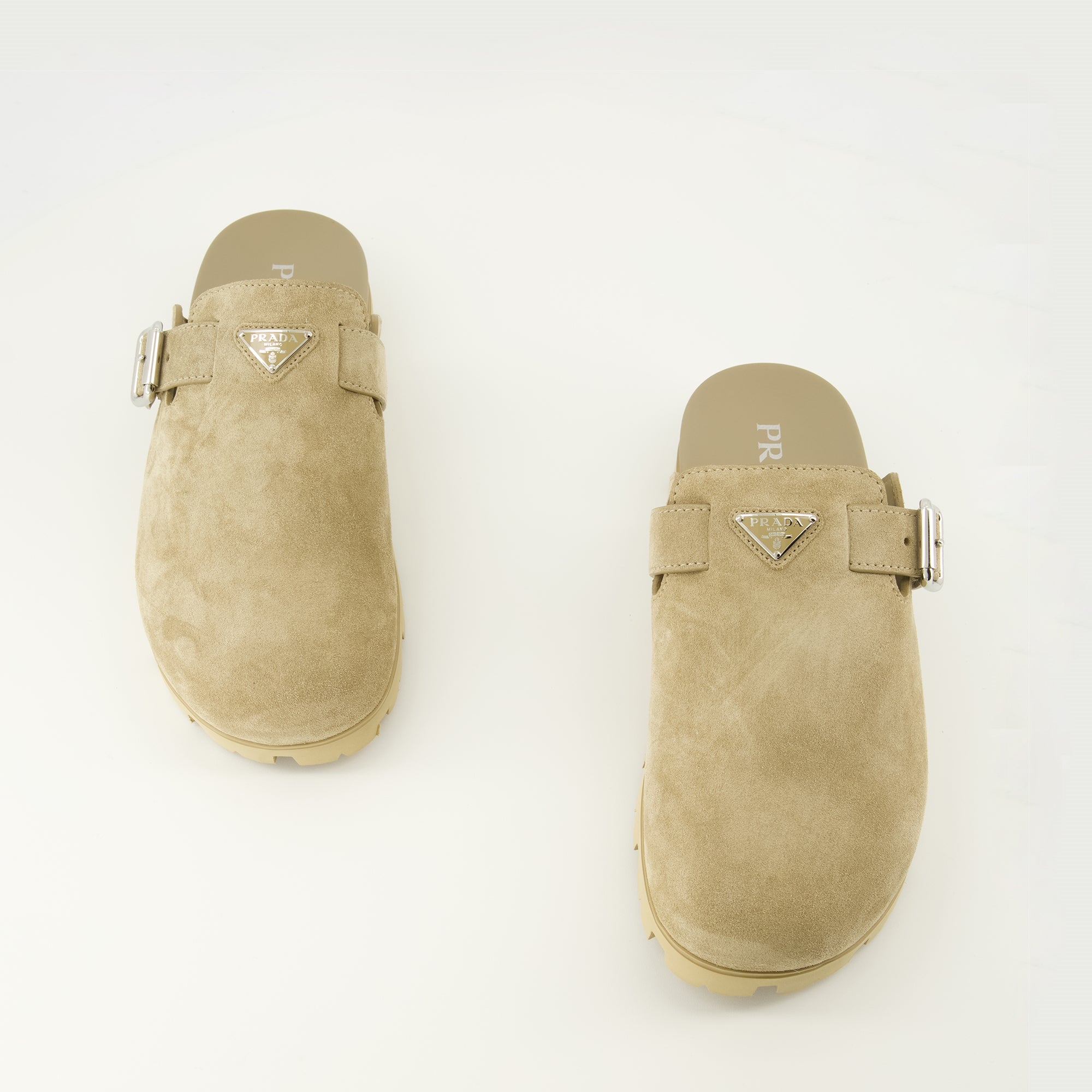 Imagen de las mules de ante beige de la marca Prada para hombres - Temporada Primavera-Verano 2026 - Vista de cima do par de sapatos