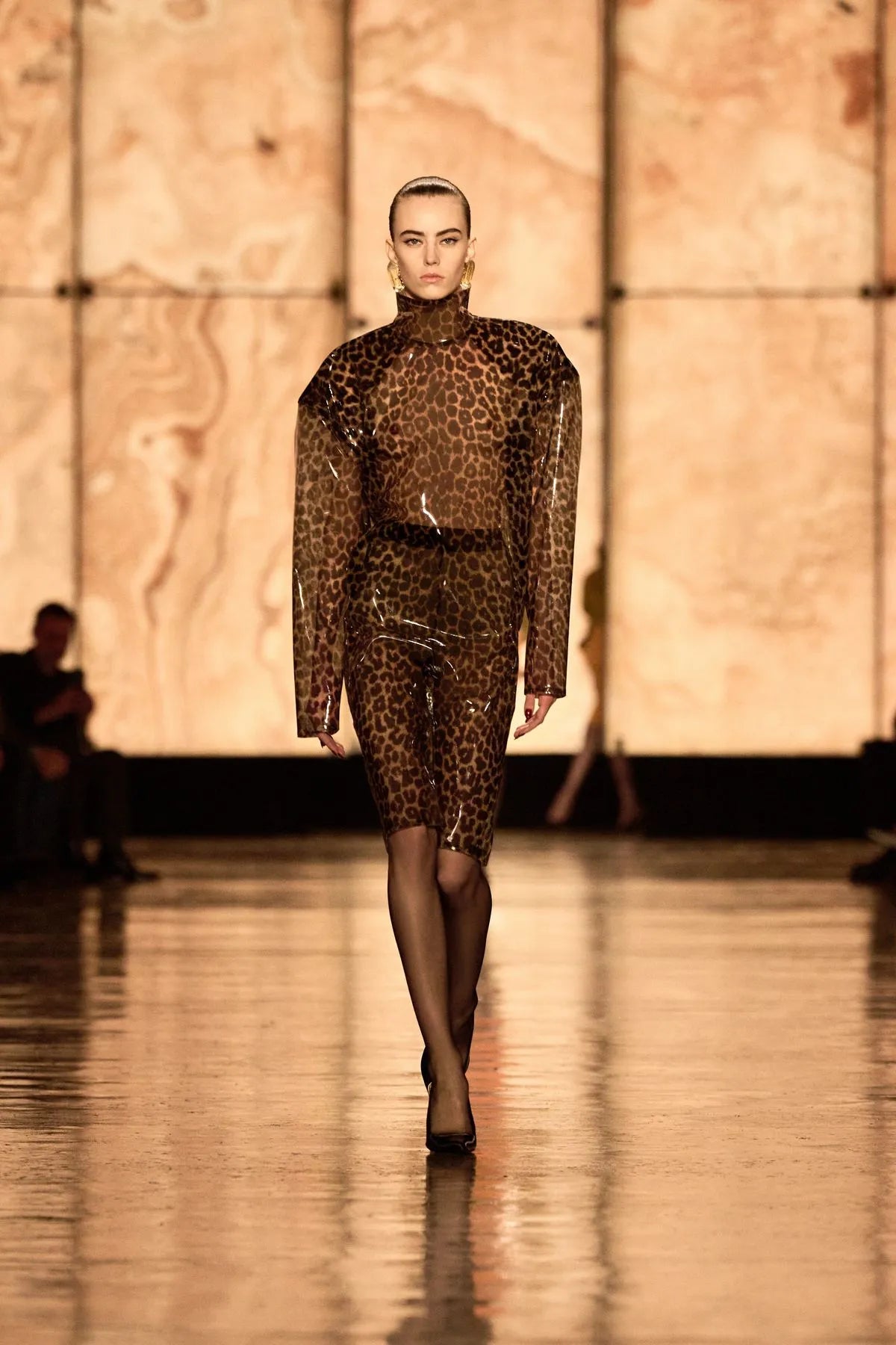 Défilé Saint Laurent – mannequin portant une combinaison moulante à imprimé léopard transparent, look glamour et audacieux sous la direction d’Anthony Vaccarello.